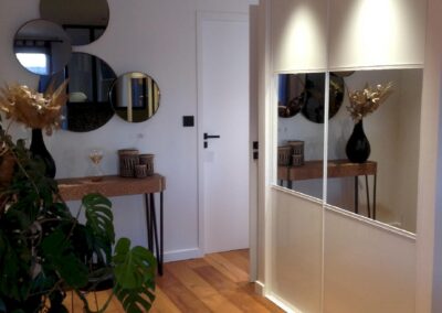 Entrée d’appartement de standing avec placard éclairé et prises intégrées, cheminements électriques invisibles