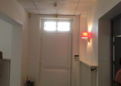 Entrée intérieure du cabinet d’avocats, éclairée par appliques et équipée d’un système électrique et de sécurité remis aux normes