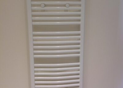 Sèche-serviettes électrique mural dans la salle de bain, raccordé à la nouvelle installation lors de la rénovation complète de l’appartement