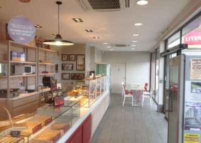 Vue de la zone de vente et de l’espace café de la boulangerie, éclairage homogène et prises adaptées aux nouveaux aménagements