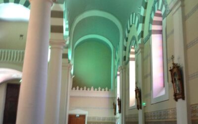 Vue latérale de la nef de l’église de saint-étienne-les-houlières, colonnes et baies éclairées en led mettant en valeur l’architecture intérieure